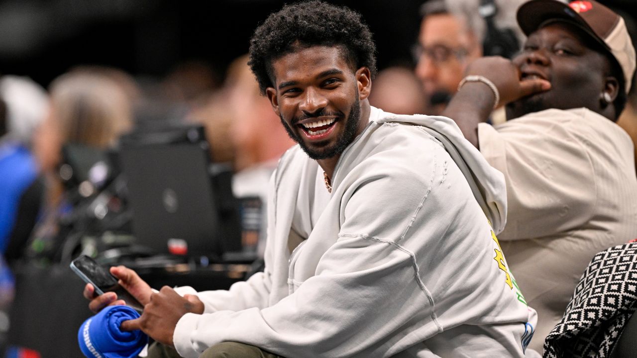 Colorado Buffaloes quarterback Shedeur Sanders laughs as he watches the game between the Dallas Mavericks and the Denver Nuggets during the second half at the American Airlines Center.