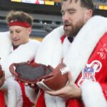 Kansas City Chiefs quarterback Patrick Mahomes (left) and tight end Travis Kelce (right) open their Netflix Christmas GameDay cake after the Chiefs defeated the Pittsburgh Steelers at Acrisure Stadium.