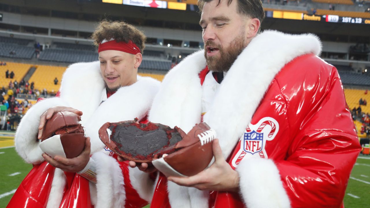 Kansas City Chiefs quarterback Patrick Mahomes (left) and tight end Travis Kelce (right) open their Netflix Christmas GameDay cake after the Chiefs defeated the Pittsburgh Steelers at Acrisure Stadium.