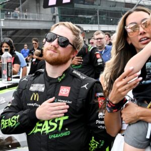 NASCAR Cup Series driver Tyler Reddick (45) stands with his wife, Alexa DeLeon Reddick, and son, Beau, during the national anthem ahead of the Brickyard 400, Sunday, July 21, 2024, at Indianapolis Motor Speedway.