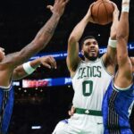 Boston Celtics forward Jayson Tatum (0) drives to the basket between Orlando Magic forward Paolo Banchero (5) and guard Jalen Suggs (4) during the second half at TD Garden
