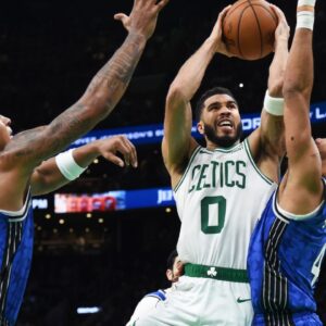 Boston Celtics forward Jayson Tatum (0) drives to the basket between Orlando Magic forward Paolo Banchero (5) and guard Jalen Suggs (4) during the second half at TD Garden