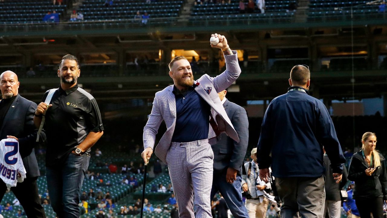 MMA fighter Conor McGregor waves to fans as he walks off the field before the game between the Chicago Cubs and the Minnesota Twins at Wrigley Field.