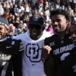 Colorado Buffaloes safety Shilo Sanders (21) and head coach Deion Sanders and quarterback Shedeur Sanders (2) and social media producer Deion Sanders Jr. following the win against the Oklahoma State Cowboys at Folsom Field.