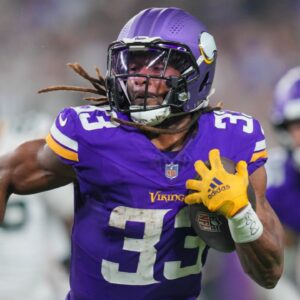 Dec 29, 2024; Minneapolis, Minnesota, USA; Minnesota Vikings running back Aaron Jones (33) runs with the ball against Green Bay Packers in the third quarter at U.S. Bank Stadium.