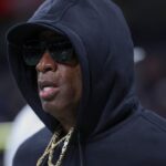 Colorado Buffaloes head coach Deion Sanders jogs on the field before the game against the Brigham Young Cougars at Alamodome.