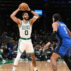 Boston Celtics forward Jayson Tatum (0) looks to pass the ball over Orlando Magic forward Paolo Banchero (5) during the second half at TD Garden.