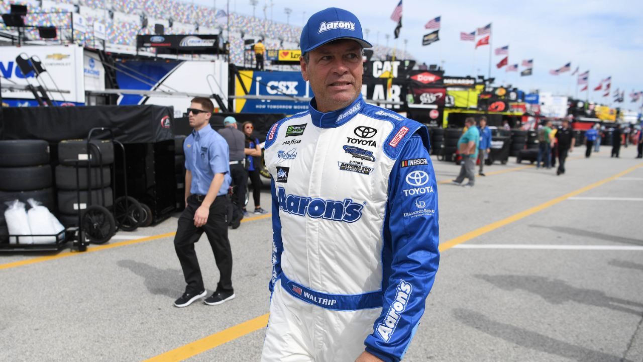 NASCAR Cup Series driver Michael Waltrip (15) walks through the garage area during practice for the Daytona 500 at Daytona International Speedway.