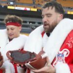 Kansas City Chiefs quarterback Patrick Mahomes (left) and tight end Travis Kelce (right) open their Netflix Christmas GameDay cake after the Chiefs defeated the Pittsburgh Steelers at Acrisure Stadium.