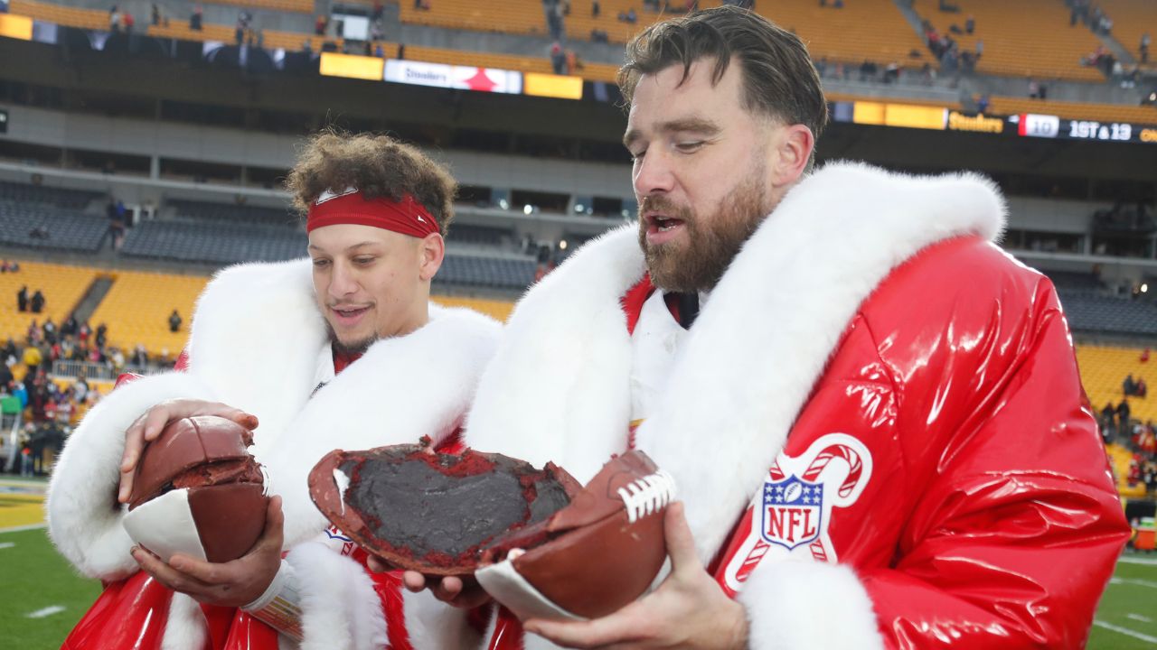 Kansas City Chiefs quarterback Patrick Mahomes (left) and tight end Travis Kelce (right) open their Netflix Christmas GameDay cake after the Chiefs defeated the Pittsburgh Steelers at Acrisure Stadium.