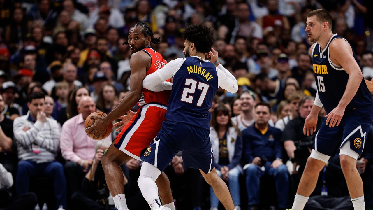 Los Angeles Clippers forward Kawhi Leonard (2) controls the ball as Denver Nuggets guard Jamal Murray (27) guards and center Nikola Jokic (15) defends in the third quarter during game two of first round for the 2025 NBA Playoffs at Ball Arena.