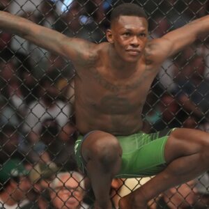 Israel Adesanya (red gloves) reacts before a bout against Jared Cannonier (blue gloves) during UFC 276 at T-Mobile Arena.
