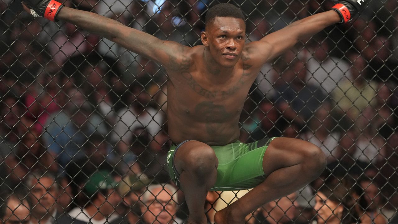 Israel Adesanya (red gloves) reacts before a bout against Jared Cannonier (blue gloves) during UFC 276 at T-Mobile Arena.