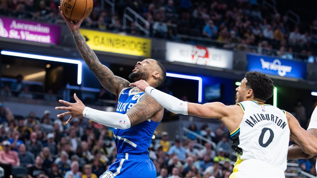 Milwaukee Bucks guard Damian Lillard (0) shoots the ball while Indiana Pacers guard Tyrese Haliburton (0) defends in the second half at Gainbridge Fieldhouse.