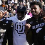 Colorado Buffaloes safety Shilo Sanders (21) and head coach Deion Sanders and quarterback Shedeur Sanders (2) and social media producer Deion Sanders Jr. following the win against the Oklahoma State Cowboys at Folsom Field.