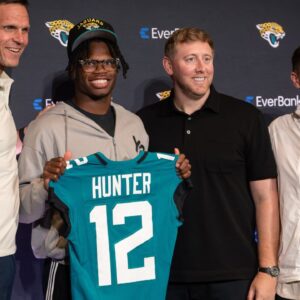 Jacksonville Jaguars first round draft pick Travis Hunter poses for a photo with executive vice president of football operations Tony Boselli, head coach Liam Coen, and general manager James Gladstone, during a press conference at Miller Electric Center.