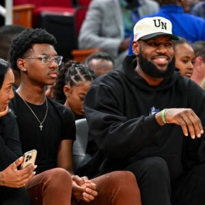 Los Angeles Lakers forward LeBron James sits with his wife Savannah James (right), son Bryce Maximus James (left) and his mother Gloria Marie James (left) court side of the between the McDonald's All American East and the McDonald's All American West at Toyota Center.