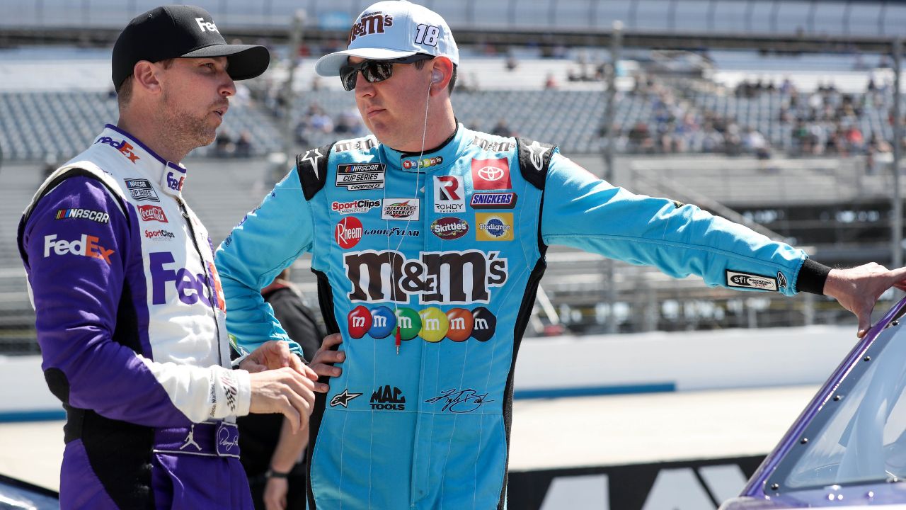 NASCAR Cup Series driver Kyle Busch (right) talks with driver Denny Hamlin (left) on pit road during qualifying for the DuraMAX Drydene 400 at Dover Motor Speedway.