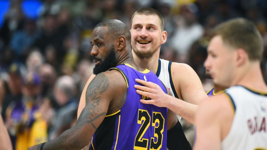 Denver Nuggets center Nikola Jokic (15) and Los Angeles Lakers forward LeBron James (23) hug before the game at Ball Arena