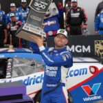 William Byron (17) hoists the trophy after his win during the Bet MGM 300 at Charlotte Motor Speedway.
