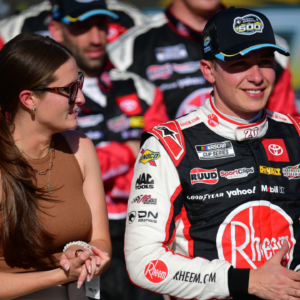 Mar 10, 2024; Avondale, Arizona, USA; NASCAR Cup Series driver Christopher Bell (20) celebrates his victory of the Shriners Childrens 500 with wife Morgan Bell at Phoenix Raceway. Mandatory Credit: Gary A. Vasquez-Imagn Images