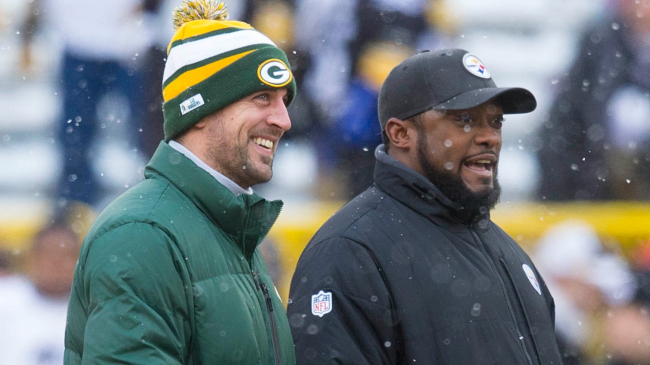 Green Bay Packers quarterback Aaron Rodgers and Pittsburgh Steelers head coach Mike Tomlin talk during warmups prior to the game at Lambeau Field.