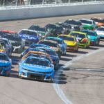 NASCAR Cup Series drivers Chase Elliott (9) and Kyle Larson (5) lead the pack during a restart at the AdventHealth 400 at Kansas Speedway.