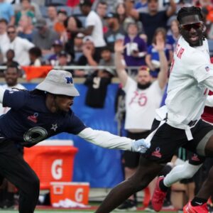 Brian Thomas Jr. of the Jacksonville Jaguars (7) carries the ball against NFC return specialist KaVontae Turpin of the Dallas Cowboys (9) during the 2025 Pro Bowl Games flag football game at Camping World Stadium.