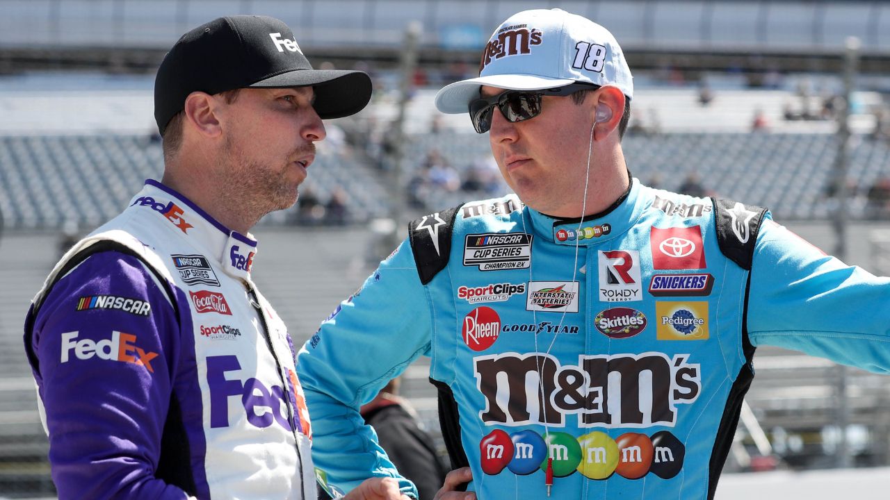 NASCAR Cup Series driver Kyle Busch (right) talks with driver Denny Hamlin (left) on pit road during qualifying for the DuraMAX Drydene 400 at Dover Motor Speedway.
