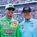 NASCAR Cup Series driver Kyle Busch (left center) and Joe Gibbs Racing owner Joe Gibbs (right center) in pit road prior to the start of the Coke Zero 400 at Daytona International Speedway.