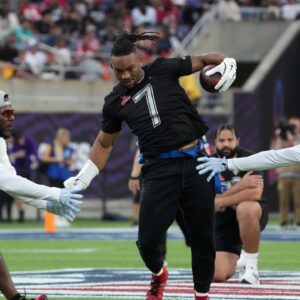 NFC running back Bijan Robinson of the Atlanta Falcons (7) carries the ball against AFC linebacker Zaire Franklin of the Indianapolis Colts (left) and cornerback Marlon Humphrey of the Baltimore Ravens during the 2025 Pro Bowl Flag Football Game at Camping World Stadium.