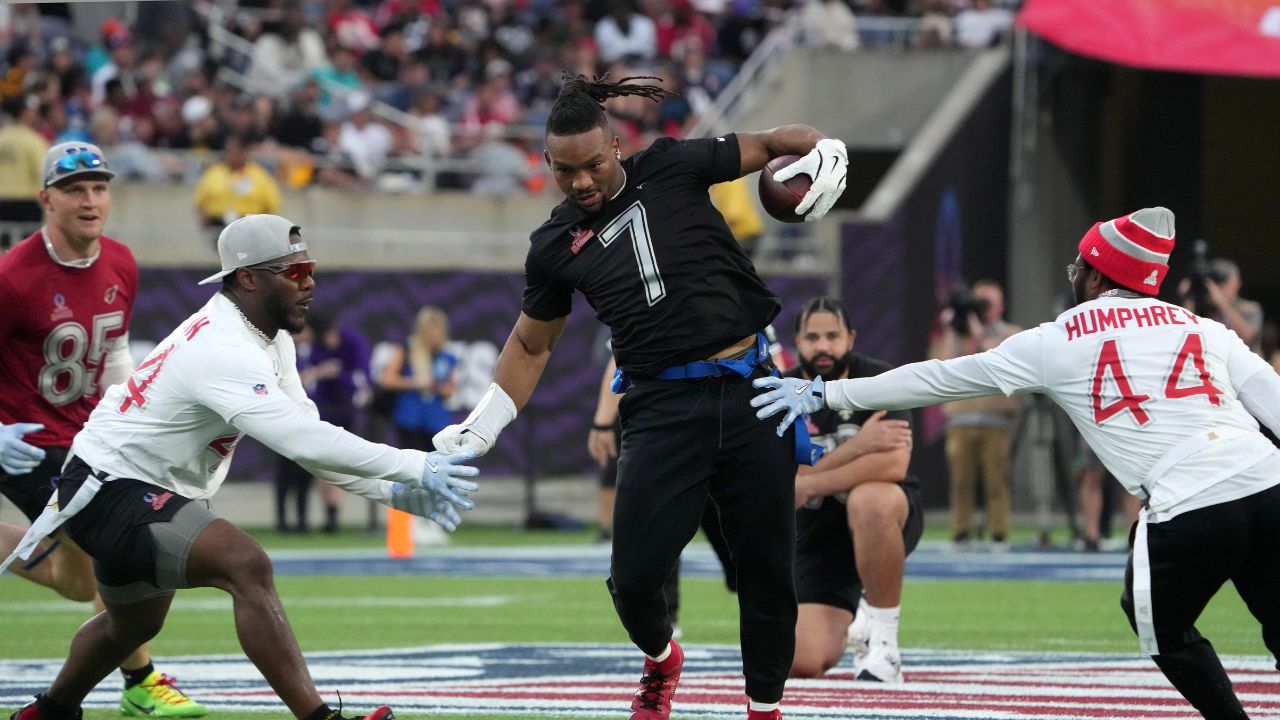 NFC running back Bijan Robinson of the Atlanta Falcons (7) carries the ball against AFC linebacker Zaire Franklin of the Indianapolis Colts (left) and cornerback Marlon Humphrey of the Baltimore Ravens during the 2025 Pro Bowl Flag Football Game at Camping World Stadium.