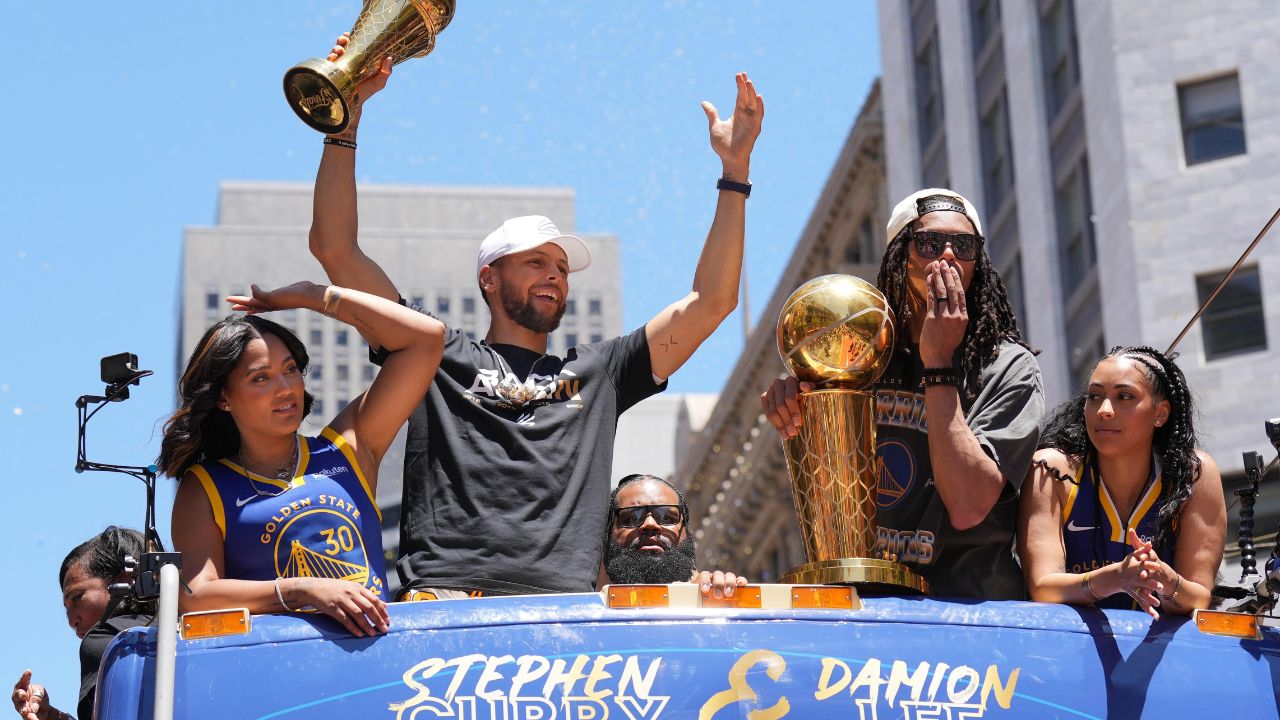 Golden State Warriors guard Stephen Curry (middle left) gestures while standing with wife Ayesha (far left) and guard Damion Lee (middle right) and his wife Sydel Curry (far right) during the Golden State Warriors championship parade in downtown San Francisco
