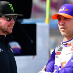 Nov 5, 2022; Avondale, Arizona, USA; NASCAR Cup Series driver Denny Hamlin (11) speaks with Kurt Busch during qualifying at Phoenix Raceway. Mandatory Credit: Gary A. Vasquez-Imagn Images