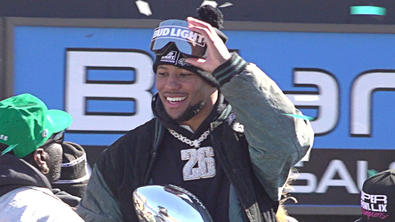 Eagles running back Saquon Barkley, center, holds the Vince Lombardi trophy during the Eagles Super Bowl championship parade on Friday, Feb. 14, 2025.