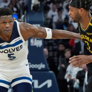 Minnesota Timberwolves guard Anthony Edwards (5) dribbles around Golden State Warriors forward Buddy Hield (7) in the first quarter during game one of the second round for the 2025 NBA Playoffs at Target Center.