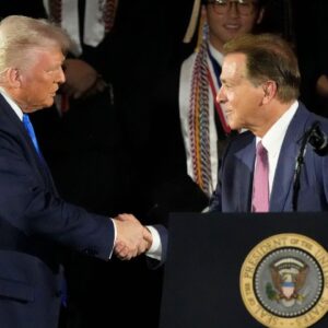 President Donald Trump shakes hands with legendary Alabama football coach Nick Saban before delivering a special commencement address to University of Alabama graduates at Coleman Coliseum. Graduation occurs over the weekend.