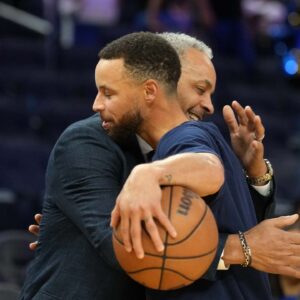 Charlotte Hornets color commentator Dell Curry (left) and Golden State Warriors guard Stephen Curry (right) hug before the game at Chase Center.