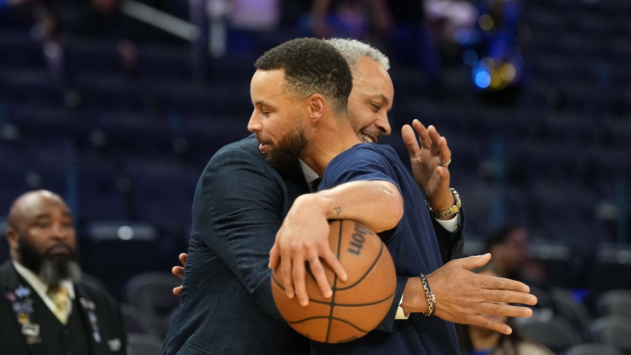 Charlotte Hornets color commentator Dell Curry (left) and Golden State Warriors guard Stephen Curry (right) hug before the game at Chase Center.