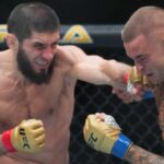 Islam Makhachev (red gloves) fights Dustin Poirier (blue gloves) during UFC 302 at Prudential Center.