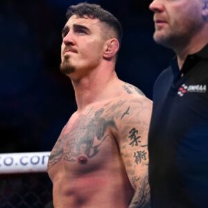 om Aspinall (red gloves) reacts to defeating Marcin Tybura (blue gloves) during UFC Fight Night at O2 Arena