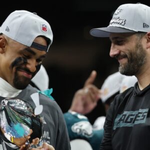 Philadelphia Eagles quarterback Jalen Hurts holds the Lombardi Trophy while standing next to Eagles head coach Nick Sirianni (R) during the championship trophy presentation after the Eagles' game against the Kansas City Chiefs in Super Bowl LIX at Caesars Superdome.