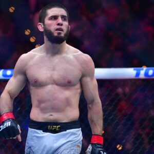 Islam Makhachev (red gloves) reacts after defeating Renato Moicano (blue gloves) in a lightweight title fight during UFC 311 at Intuit Dome.