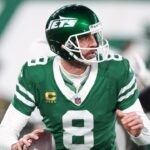 New York Jets quarterback Aaron Rodgers (8) rolls out during the first half against the Miami Dolphins at MetLife Stadium.
