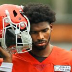 Cleveland Browns quarterback Shedeur Sanders (12) listens to the play calling on the sideline during an NFL practice at the Cleveland Browns training facility on Wednesday, May 28, 2025, in Berea, Ohio.