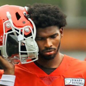 Cleveland Browns quarterback Shedeur Sanders (12) listens to the play calling on the sideline during an NFL practice at the Cleveland Browns training facility on Wednesday, May 28, 2025, in Berea, Ohio.