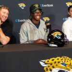 Jacksonville Jaguars ead Coach Liam Coen, left, has a laugh with Jacksonville Jaguars’ first-round pick, Colorado Buffaloes wide receiver and defensive back Travis Hunter, center, during a press conference Friday, March 25, 2025 at Miller Electric Center in Jacksonville, Fla. with General Manager James Gladstone, right