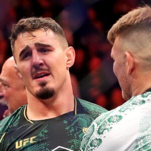 Tom Aspinall (blue gloves) reacts to beating Sergei Pavlovich (red gloves) during UFC 295 at Madison Square Garden.