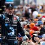 Former NASCAR Cup Series driver Jimmie Johnson (84) walks onto the driver introduction stage to greet fans before the Daytona 500 at Daytona International Speedway.