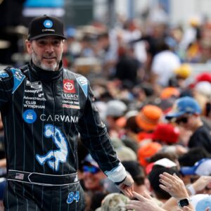 Former NASCAR Cup Series driver Jimmie Johnson (84) walks onto the driver introduction stage to greet fans before the Daytona 500 at Daytona International Speedway.